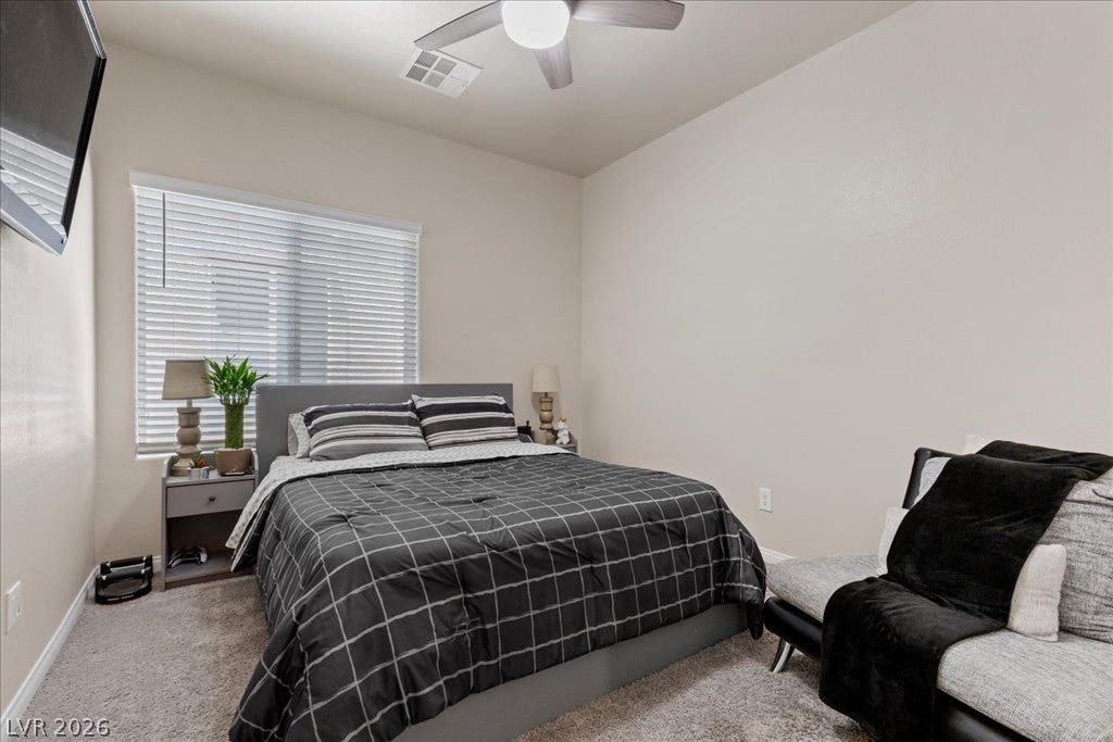 A comfortable bedroom features carpet flooring and a ceiling fan for optimal airflow.