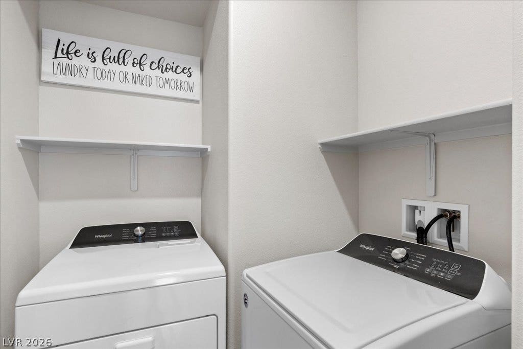 A dedicated laundry space offers practical convenience with overhead shelving for organization.