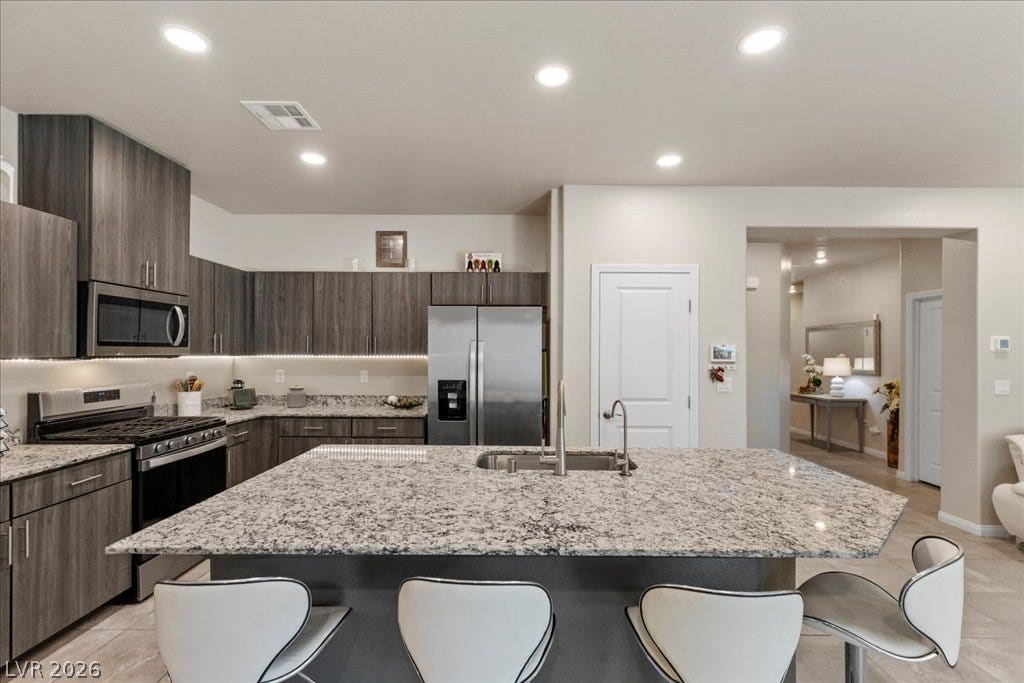 A well-appointed kitchen features ample counter space with a large island and modern stainless steel appliances.