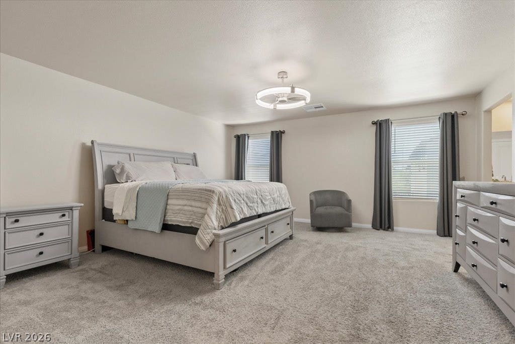 Comfortable bedroom features soft carpeting, recessed lighting, and a modern ceiling fan.