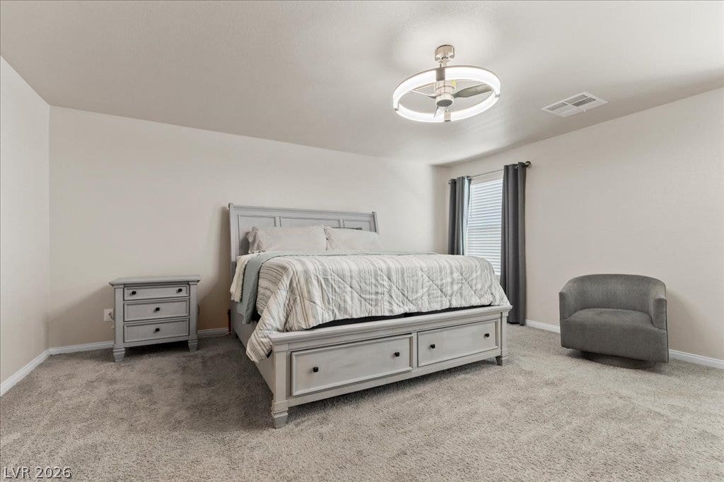A tranquil bedroom featuring plush carpeting and a sophisticated lighting fixture, perfect for unwinding.