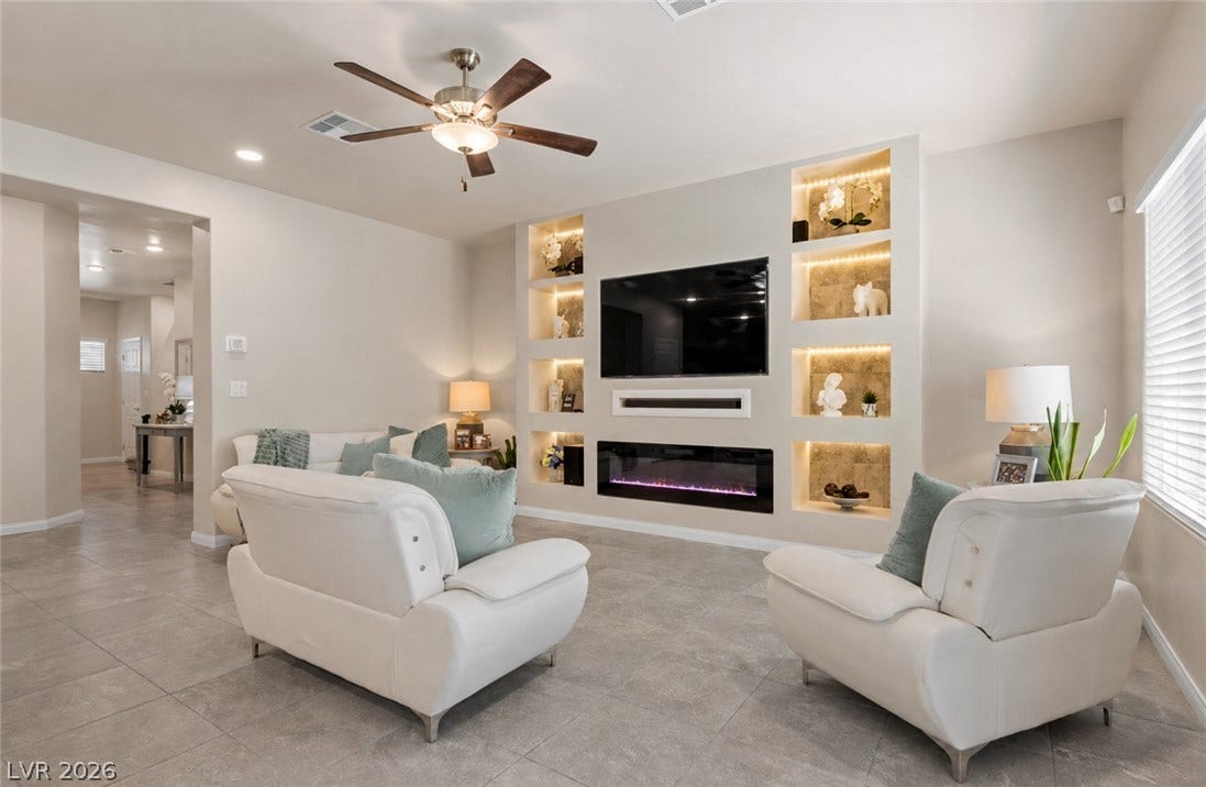 Recessed lighting illuminates this bright, inviting living area with a contemporary fireplace and tiled flooring.