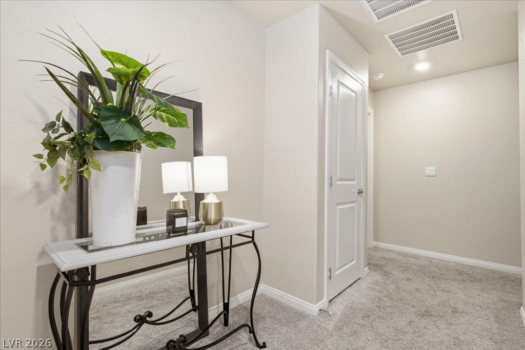 A welcoming entry hallway showcases plush carpeting and contemporary fixtures, hinting at a refined living space.