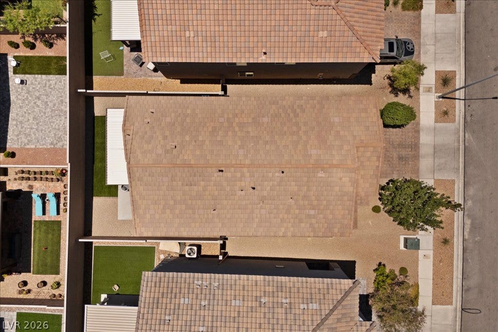 An aerial perspective showcases the pristine yard spaces and tile roofs of adjacent homes.