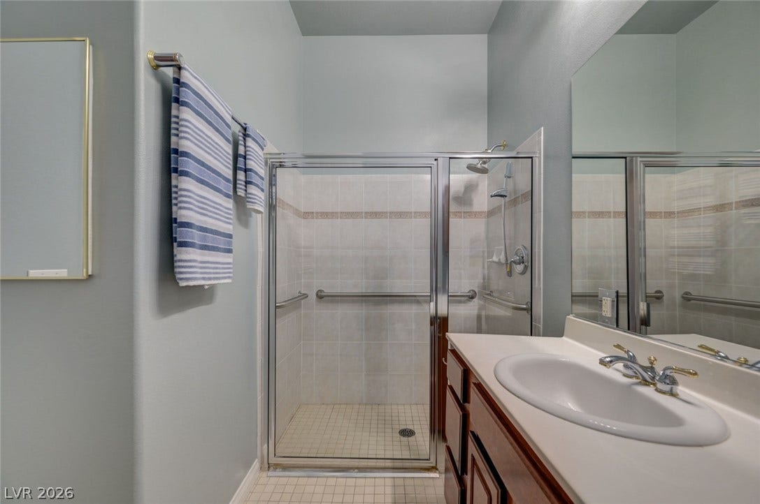 207 Kaelyn Street, #5, Boulder City, NV 89005 High ceilings and a glass-enclosed walk-in shower elevate this clean, functional bathroom design.