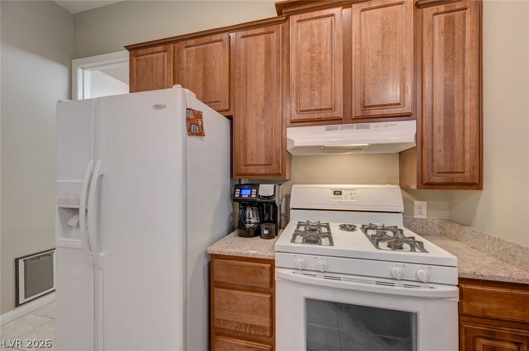 207 Kaelyn Street, #5, Boulder City, NV 89005 Rich wood cabinetry surrounds integrated appliances above durable stone countertops.
