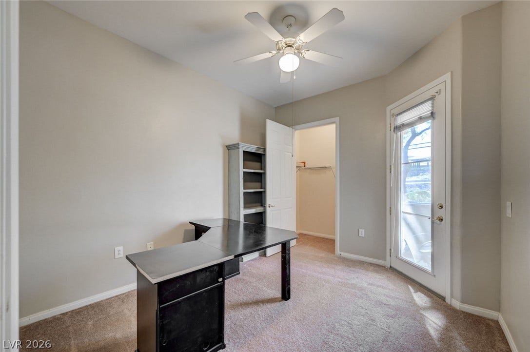207 Kaelyn Street, #5, Boulder City, NV 89005 Soft carpeting pairs with outdoor access through a glass door to enhance this versatile workspace.