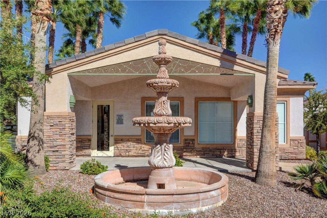 207 Kaelyn Street, #5, Boulder City, NV 89005 A classic tiered stone fountain centers the entry landscape flanked by towering palm trees.