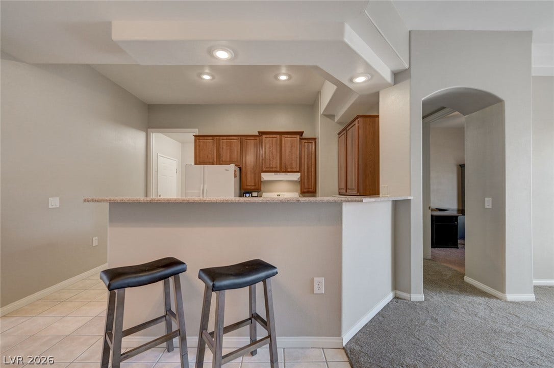 207 Kaelyn Street, #5, Boulder City, NV 89005 A breakfast bar with stone counters connects the kitchen to the main living areas.