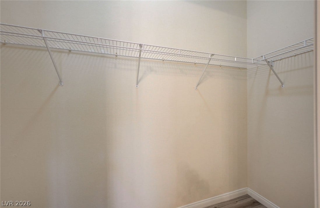 207 Kaelyn Street, #5, Boulder City, NV 89005 Wire shelving lines the walls of this walk-in closet featuring wood-look flooring.