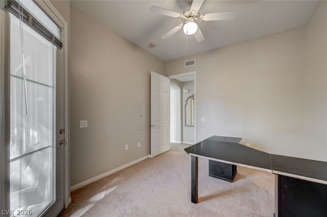 207 Kaelyn Street, #5, Boulder City, NV 89005 A glass door floods this versatile space with natural light over soft carpeting.
