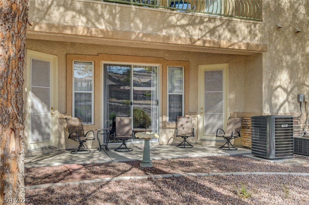 207 Kaelyn Street, #5, Boulder City, NV 89005 A shaded concrete patio offers a private outdoor retreat beneath stucco walls.