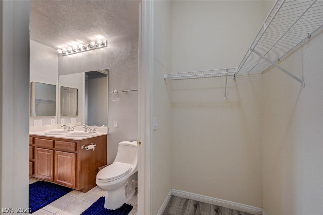 207 Kaelyn Street, #5, Boulder City, NV 89005 Functional layout connects a classic vanity bathroom to a private closet with wire shelving.