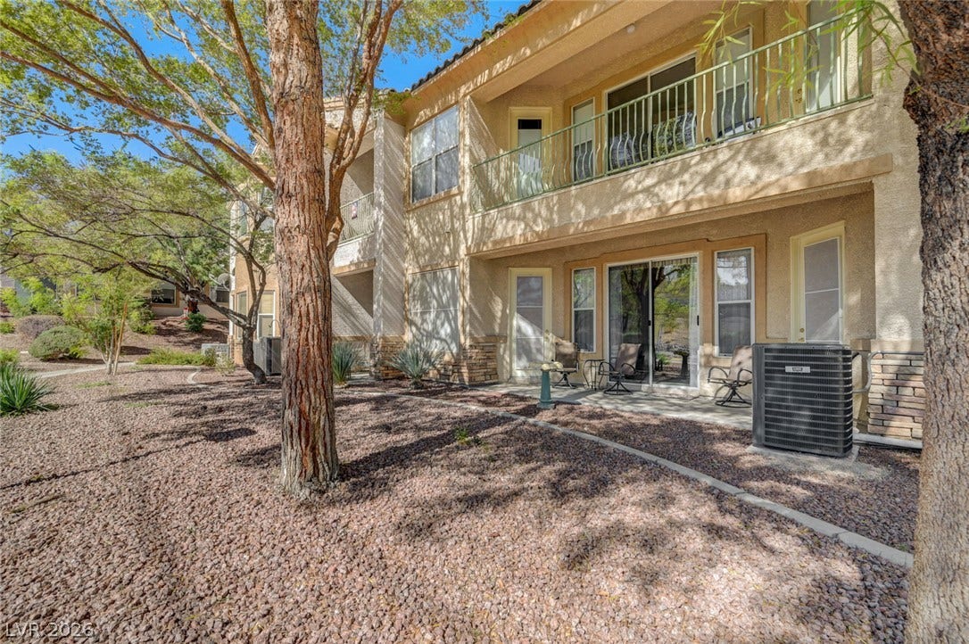 207 Kaelyn Street, #5, Boulder City, NV 89005 Mature trees shade the private ground-floor patio and upper-level balcony of this stucco exterior.