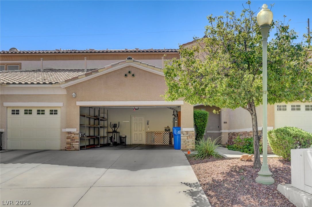207 Kaelyn Street, #5, Boulder City, NV 89005 An open multi-car garage fronts a paved driveway under a classic tiled roofline.