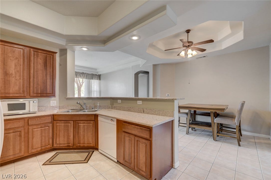 207 Kaelyn Street, #5, Boulder City, NV 89005 An open layout connects the kitchen to the dining area under a tray ceiling.