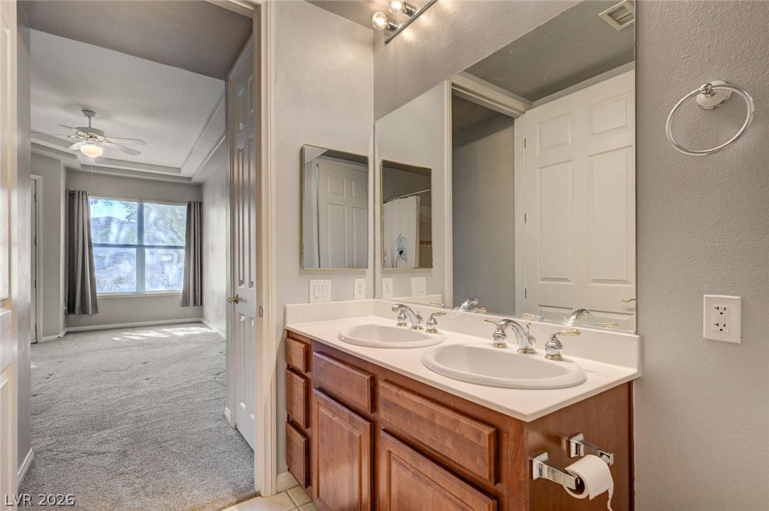 207 Kaelyn Street, #5, Boulder City, NV 89005 A spacious vanity area connects seamlessly to an adjacent bedroom with soft neutral carpeting.