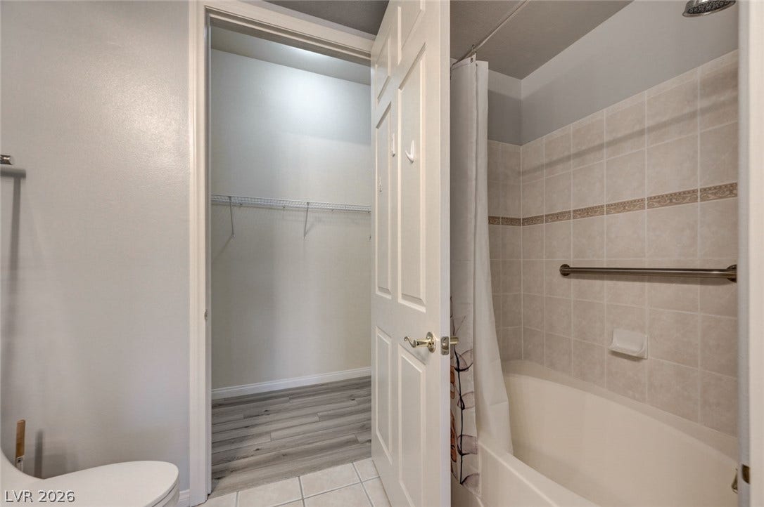 207 Kaelyn Street, #5, Boulder City, NV 89005 Tiled walls surround the soaking tub next to a walk-in closet entry.