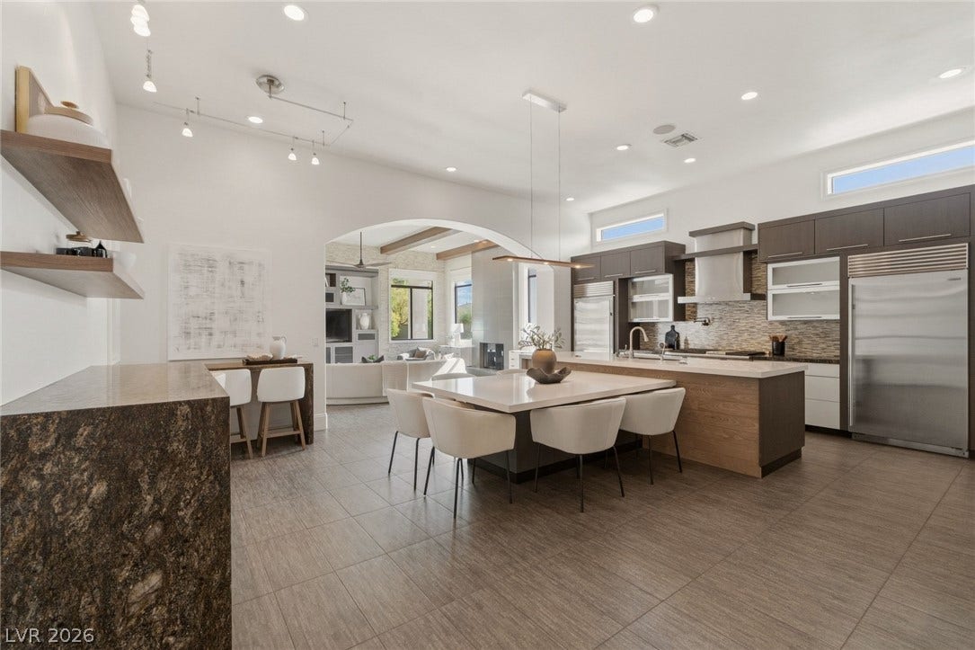 An arched doorway connects the gourmet kitchen and dining area to the main living space.