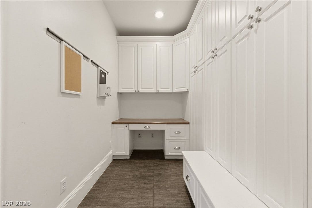 Custom cabinetry and a built-in desk optimize this functional home workspace.