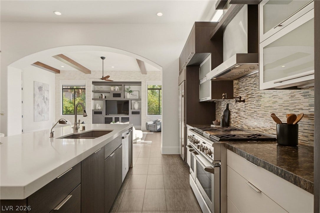 An arched doorway connects the modern kitchen to the adjacent living area.