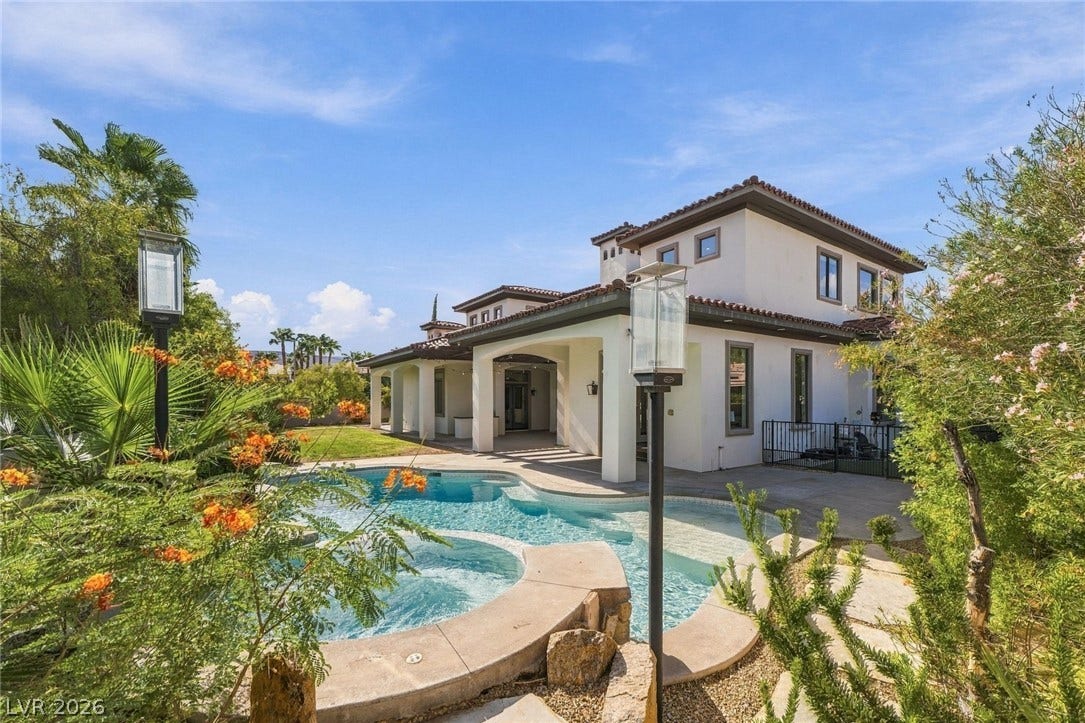 Mediterranean-inspired architecture highlights this backyard oasis featuring a custom pool and integrated spa.