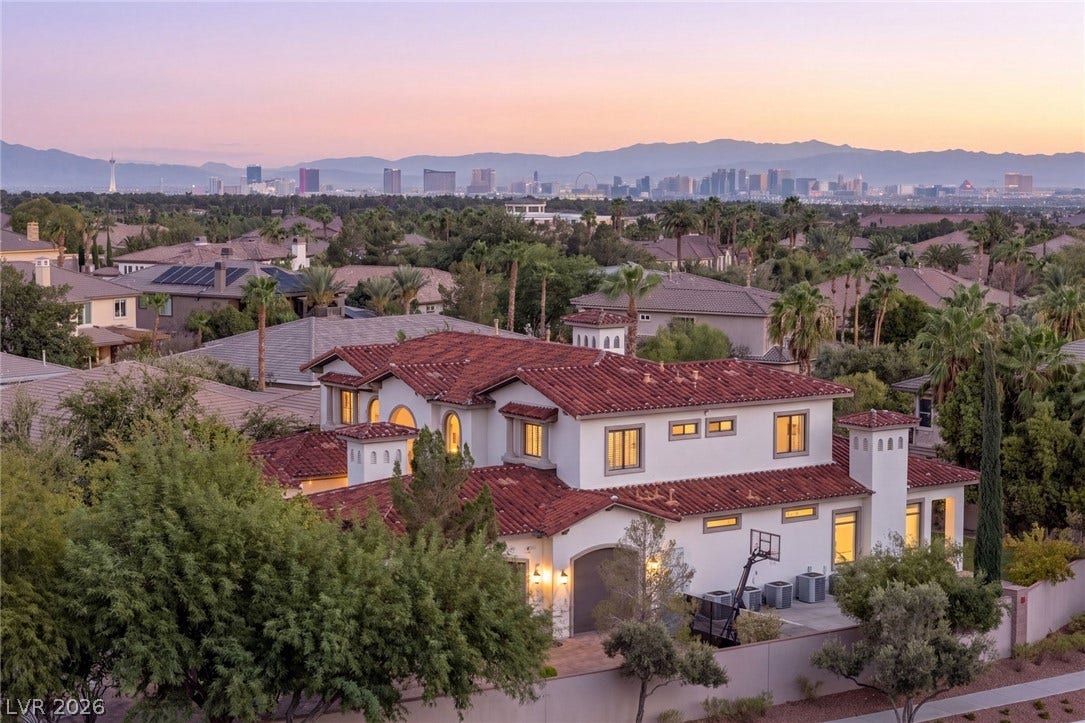 Distant city skyline and mountain views create a picturesque backdrop for this Mediterranean style home.