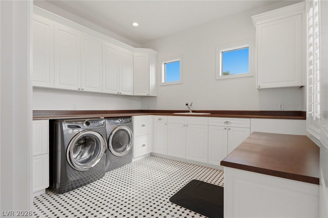 Gleaming cabinetry and classic tile floors elevate this functional utility space.