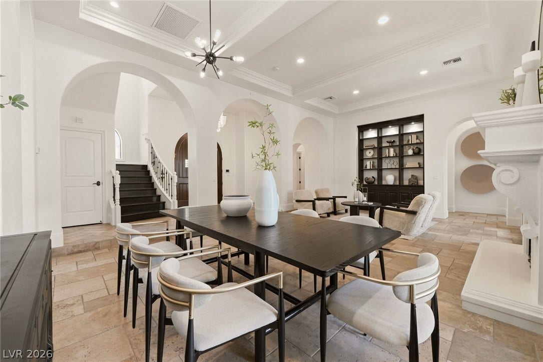 Arched entryways and natural stone tile floors enhance this formal dining space.