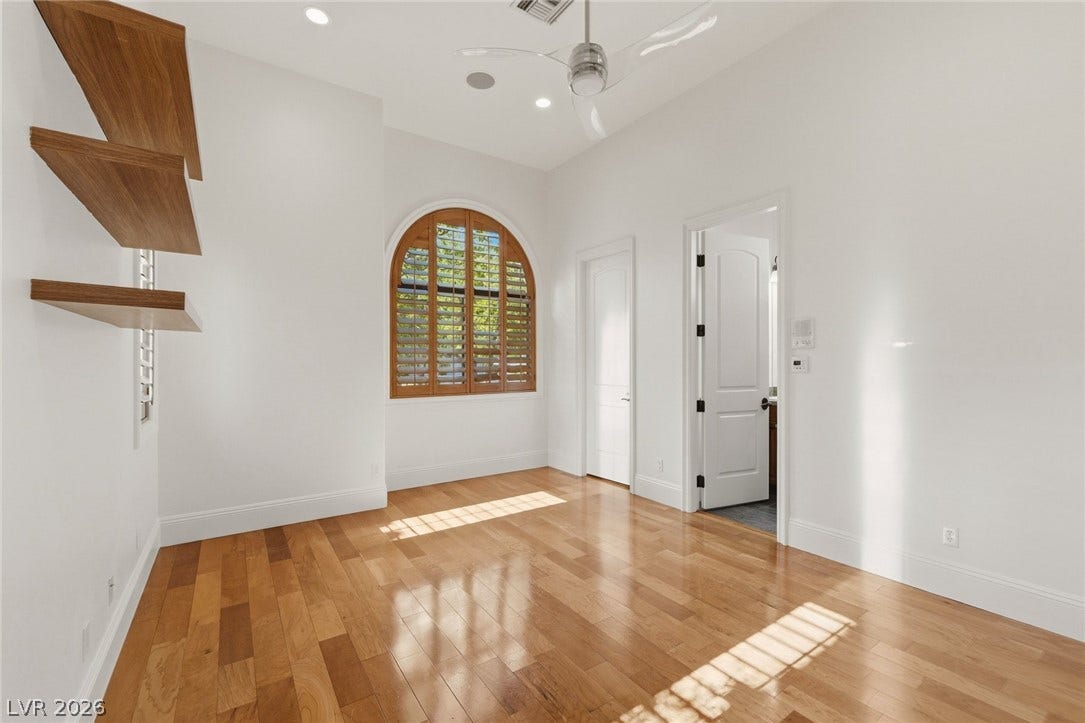Warm hardwood floors and an arched window highlight this versatile space.