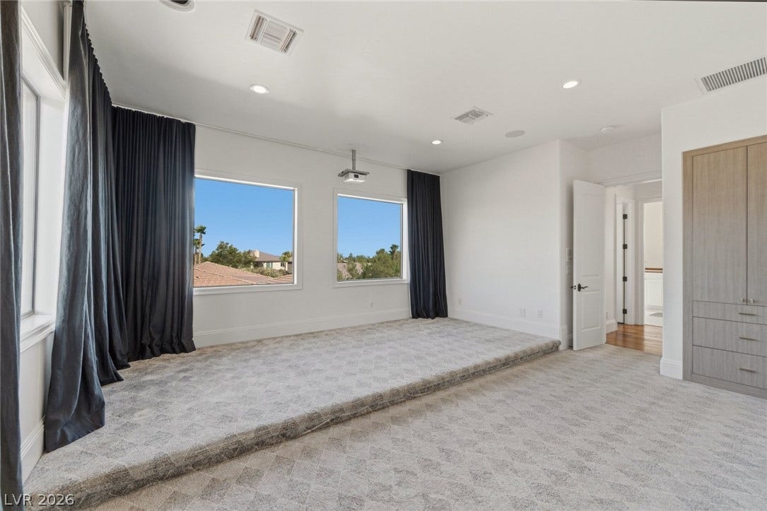 Large windows bring natural light into this carpeted space featuring a stepped floor design.