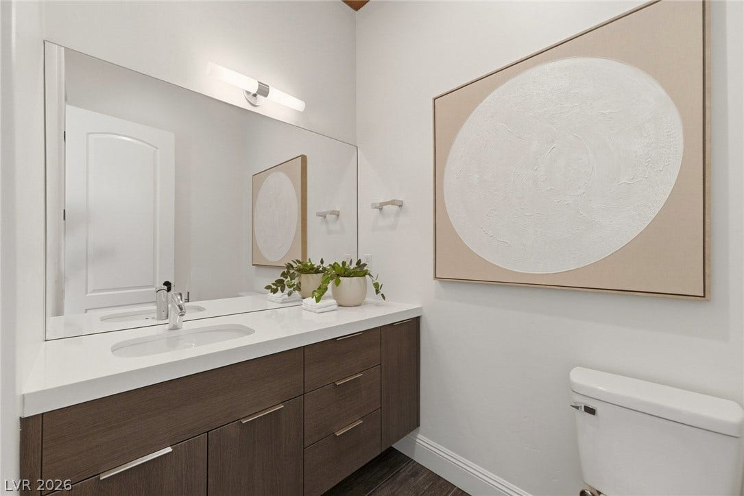 A modern vanity with a solid surface countertop anchors this clean half bath.