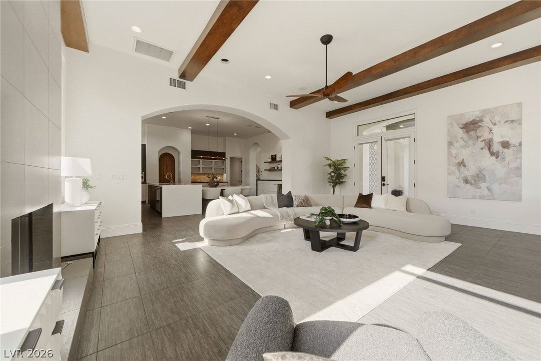Rich wood beams draw the eye upward across a spacious, open main living area.