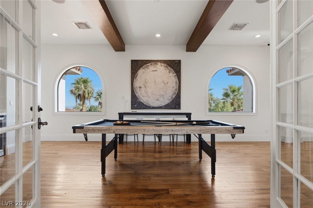 Rich hardwood floors and exposed ceiling beams create a warm, inviting atmosphere.