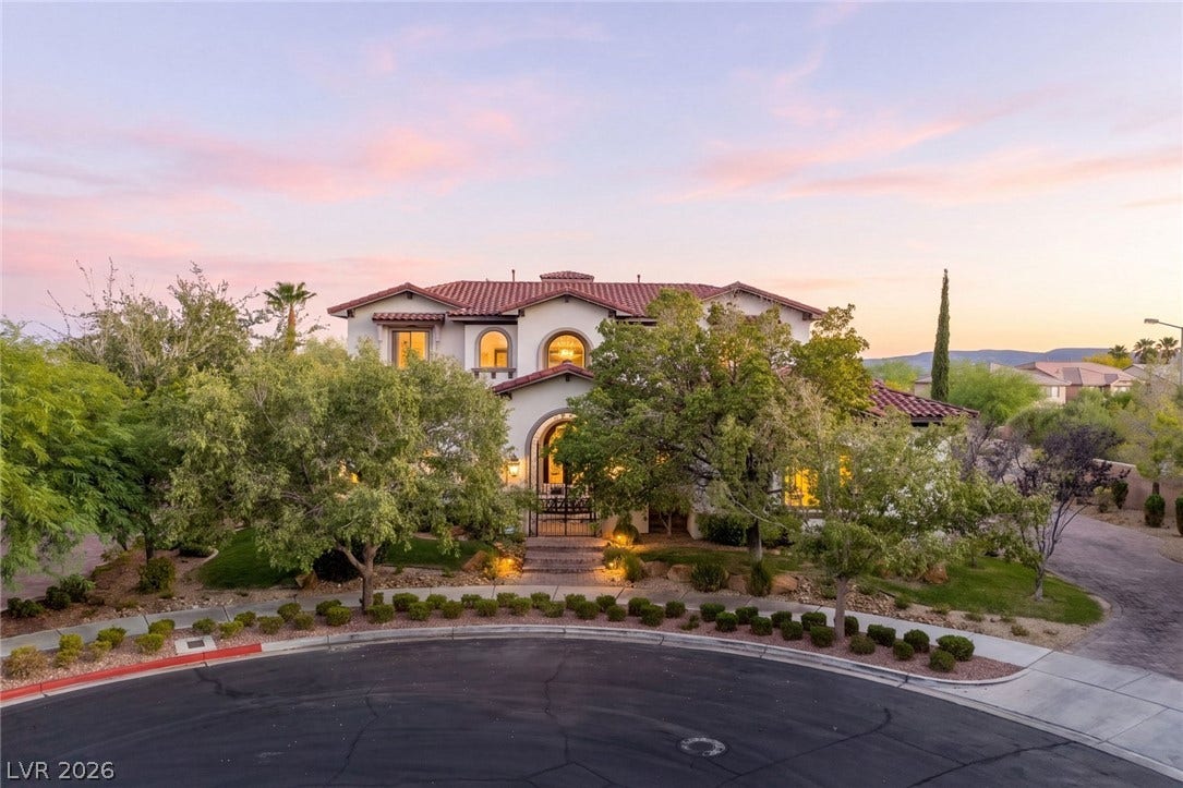 Spanish-style architecture defined by a classic tile roof and prominent arched windows stands out at dusk.