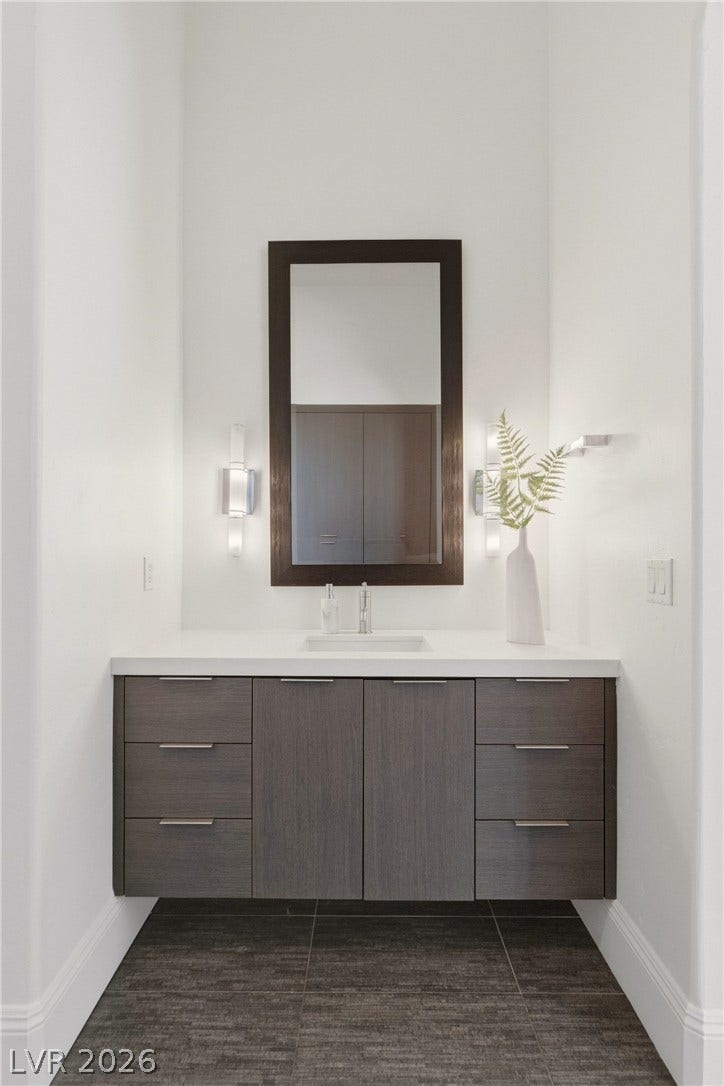 High ceilings and a floating vanity define this modern powder room alcove.