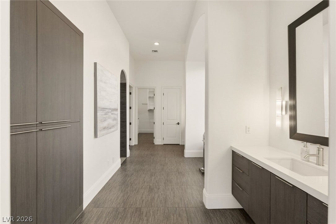 Sleek modern cabinetry and textured flooring define this elegant transitional hallway vanity space.