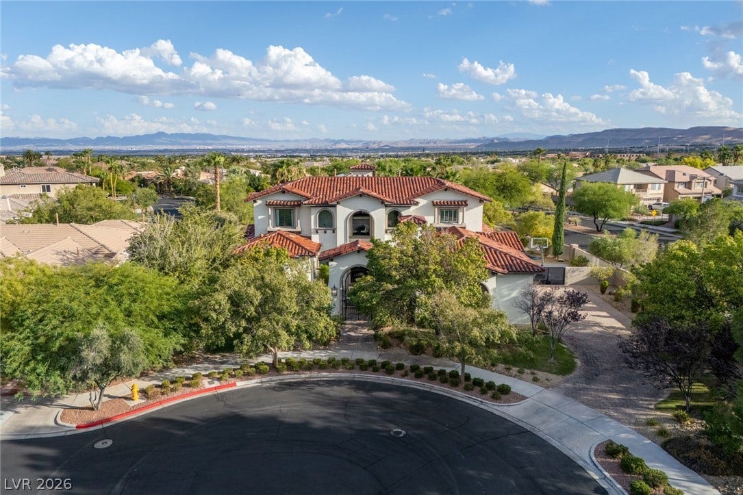 Spanish tile roofing and grand arched windows define this elegant multi-level desert estate.