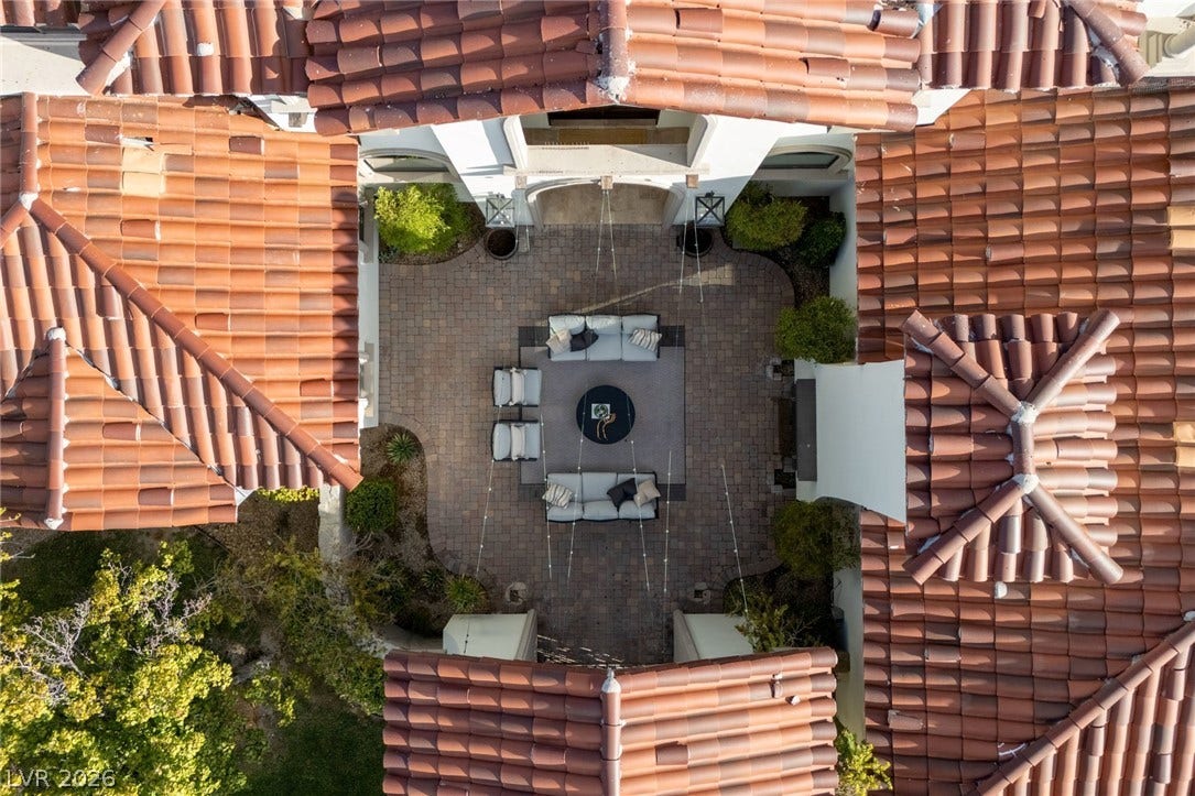 An aerial perspective reveals a private courtyard enclosed by elegant Spanish tile roofs.