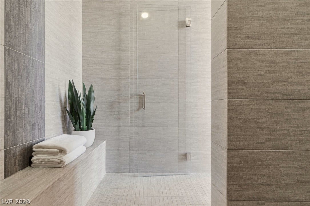 Streamlined tile surfaces and a glass-enclosed shower entry create a modern wellness retreat.