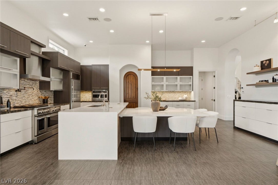 A spacious kitchen features sleek modern cabinetry, quartz countertops, and a seamless open floorplan.