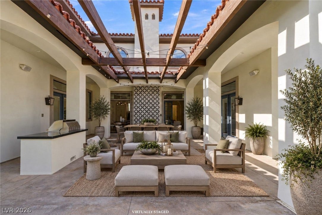 An open courtyard connects indoor and outdoor spaces under a wood beam pergola.