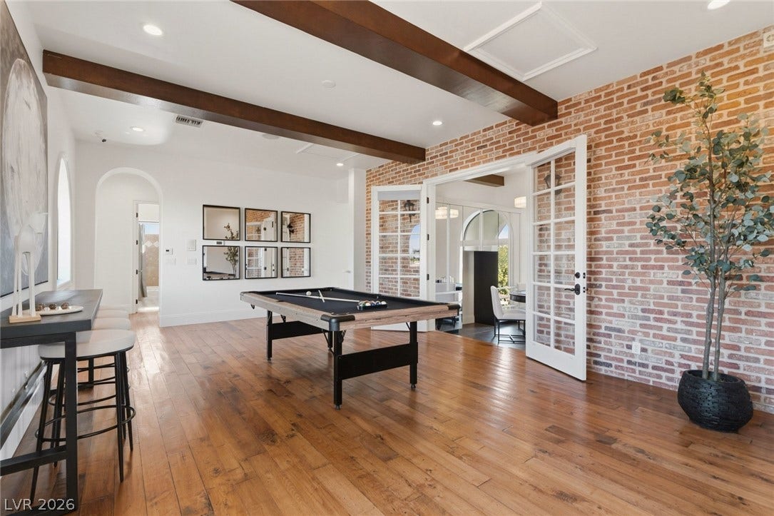 Rich hardwood floors complement the exposed brick wall and handsome ceiling beams.