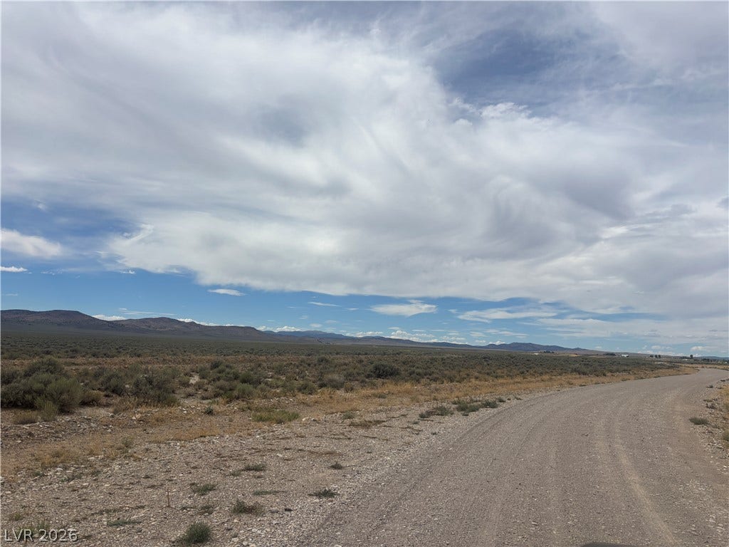 Preston Dump Road, Ely, NV 89301 A sweeping dirt road curves through the vast desert landscape toward distant mountain ranges.