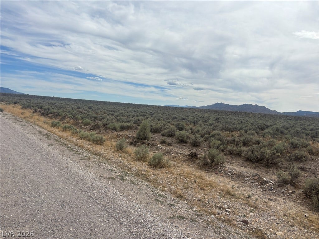 Preston Dump Road, Ely, NV 89301 Distant mountain peaks rise above vast desert terrain bordering a quiet gravel road.