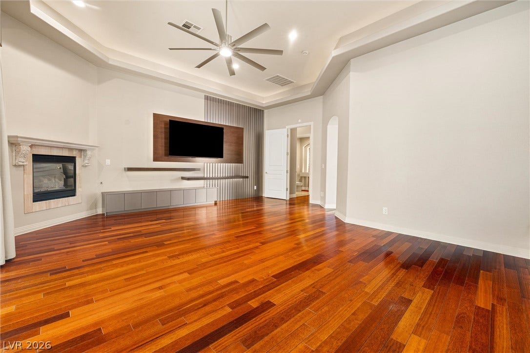 1517 Marbella Ridge Court, Las Vegas, NV 89117 Rich hardwood flooring complements the tray ceiling and elegant fireplace in this inviting space.