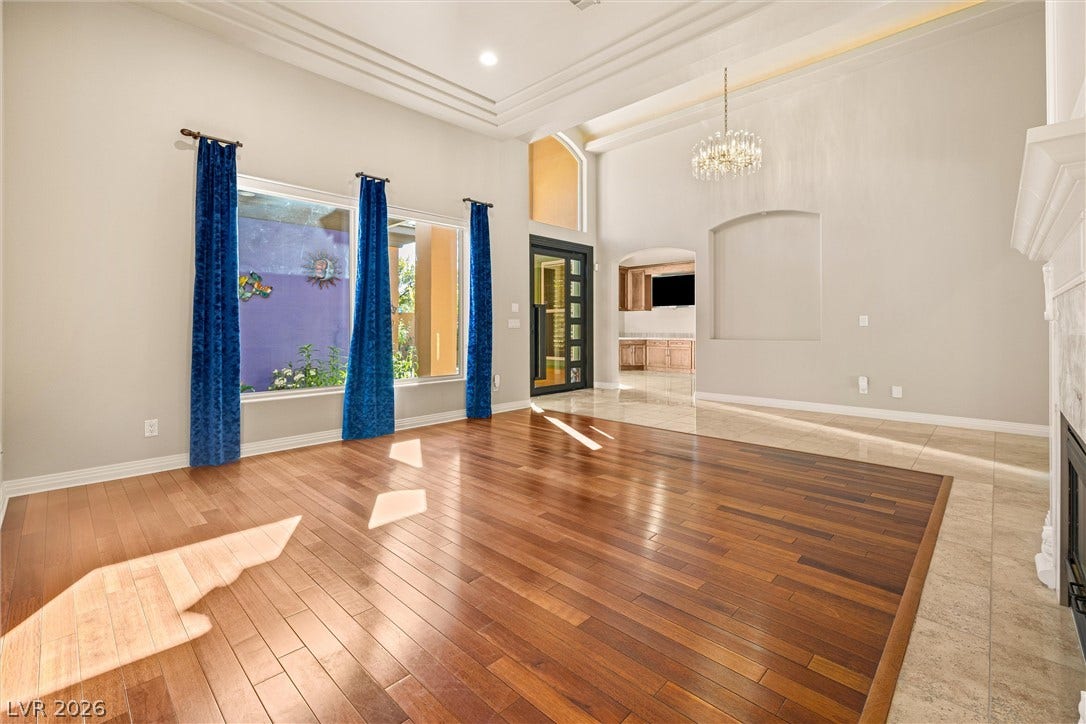 1517 Marbella Ridge Court, Las Vegas, NV 89117 Polished hardwood flooring and a towering ceiling define this elegant, light-filled gathering space.