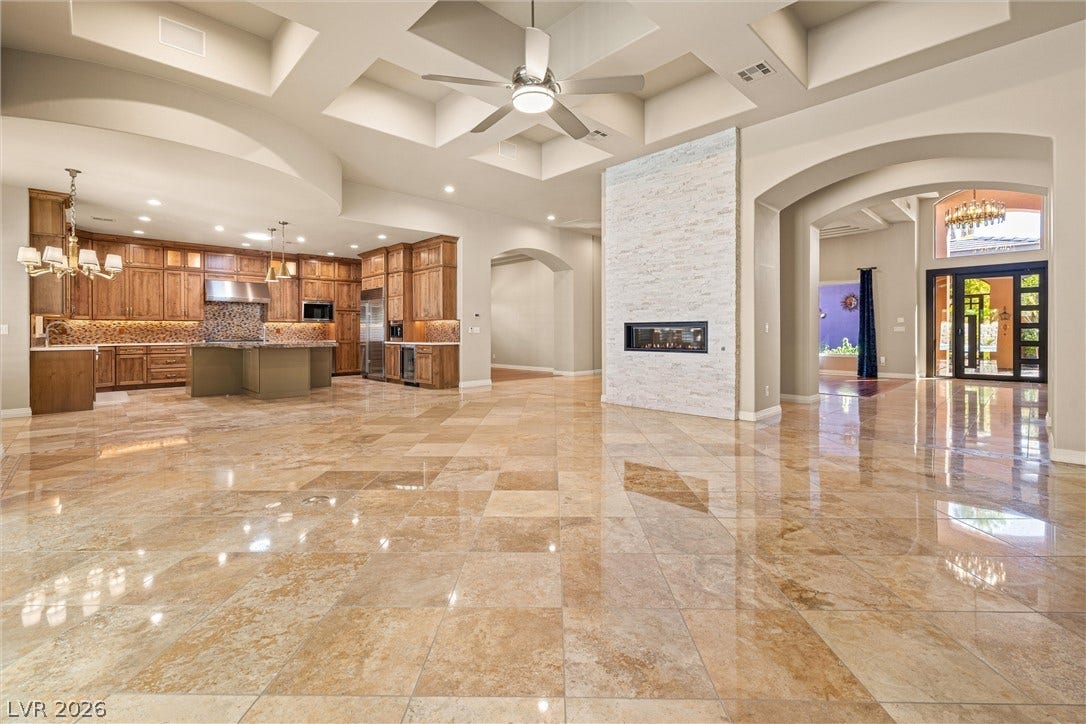 1517 Marbella Ridge Court, Las Vegas, NV 89117 Gleaming stone tile floors anchor this open living area under a towering coffered ceiling.