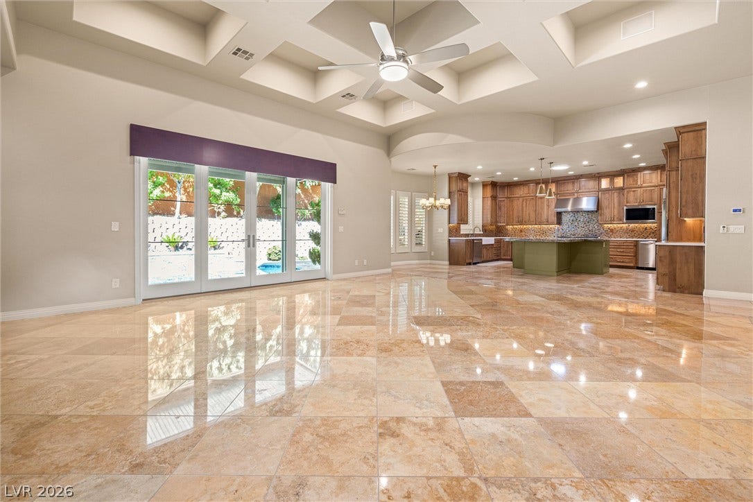 1517 Marbella Ridge Court, Las Vegas, NV 89117 Polished stone flooring reflects natural light streaming through glass doors in this open floor plan.