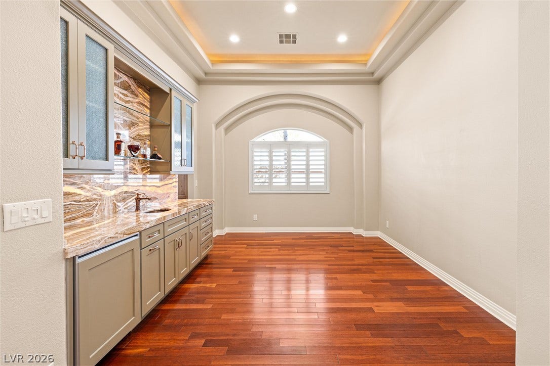 1517 Marbella Ridge Court, Las Vegas, NV 89117 Gleaming hardwood floors and a built-in wet bar define this elegant transitional space.